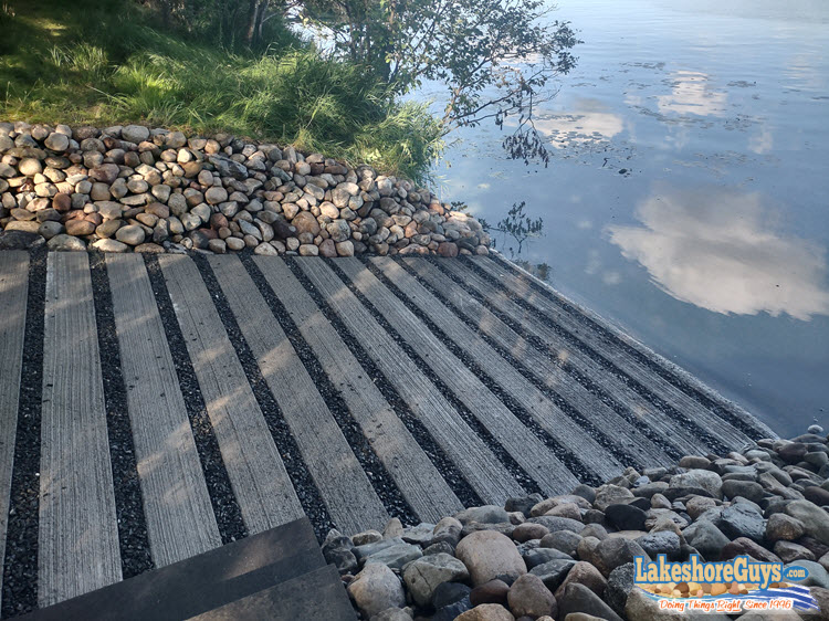 The finished boat ramp, all gravel and concrete, edged by riprap on both sides